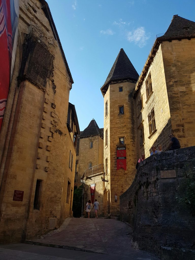 Charming medieval architecture in Sarlat-la-Canéda's narrow streets with tourists exploring.