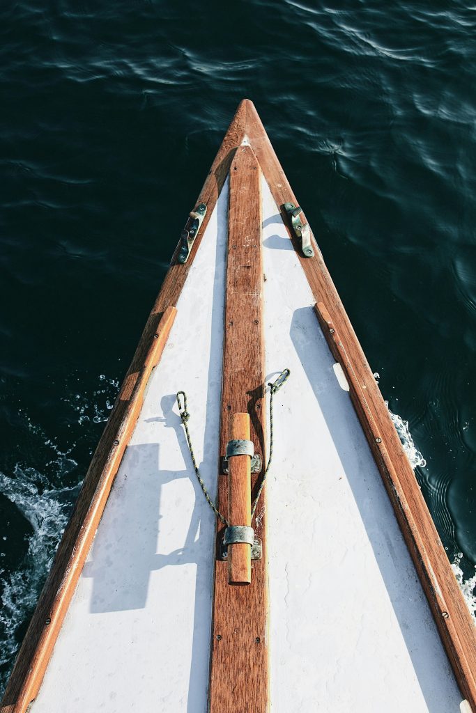 Top view of a wooden boat sailing in the clear waters of Bretagne, France.