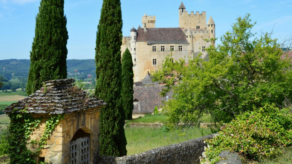 Charming view of a medieval castle with lush greenery in summer, perfect travel destination.