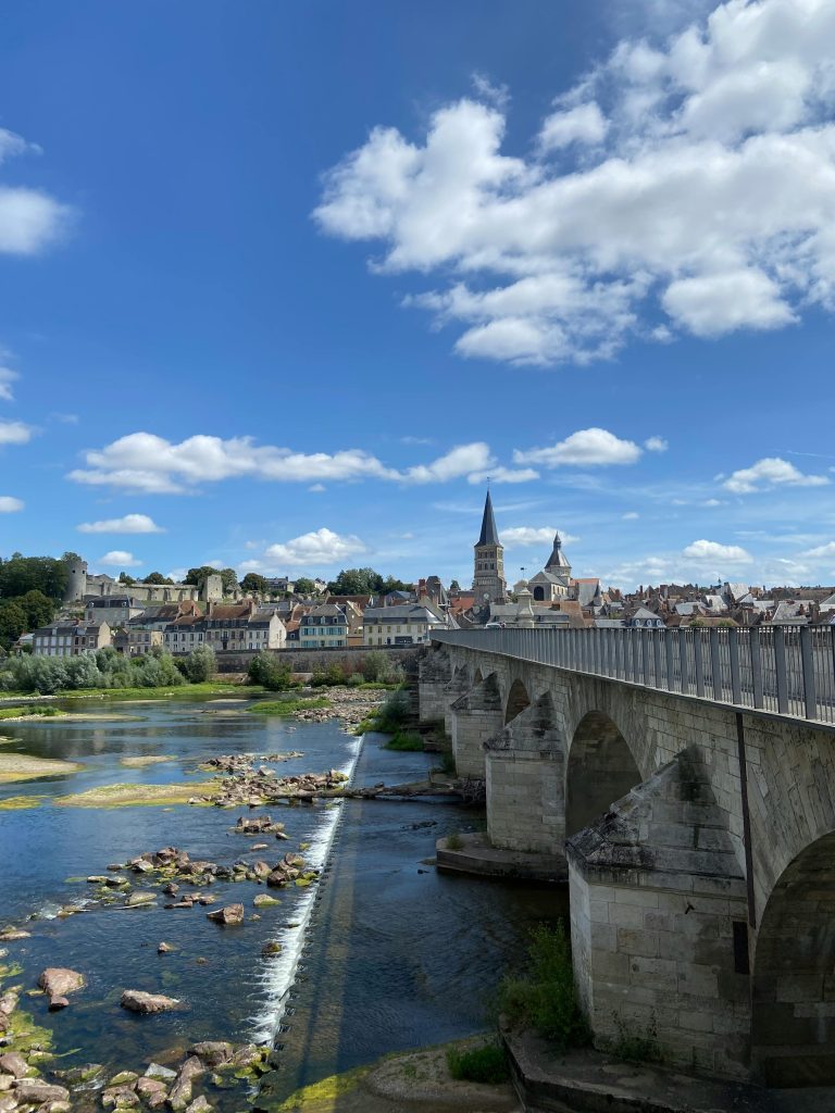 Picturesque view of historic bridge and town of La Charité-sur-Loire, France on a sunny day.