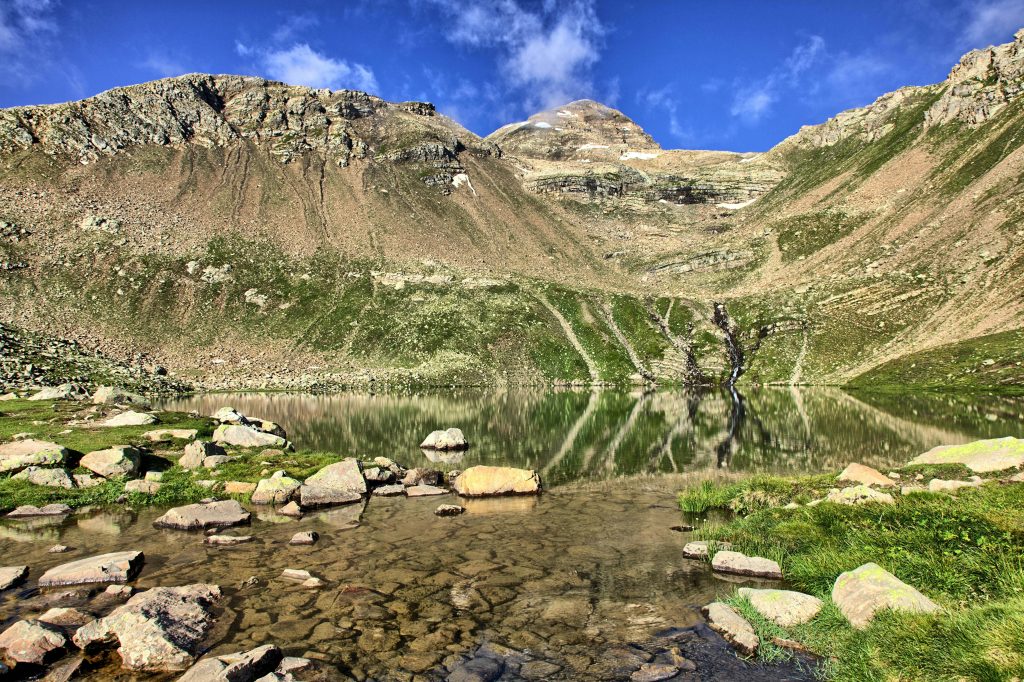 Sunlit mountain and lake reflection in Argentières, France, showcasing natural beauty.