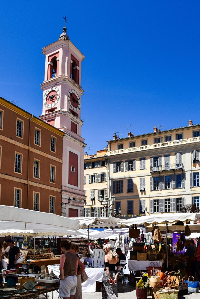 Bustling outdoor market in Nice, Provence-Alpes-Côte d'Azur, under a bright blue sky.