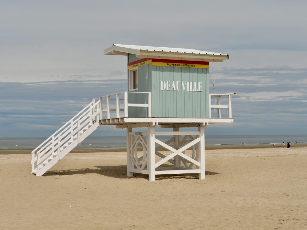 Lifeguard station on Deauville beach in Normandy, France under a cloudy sky.