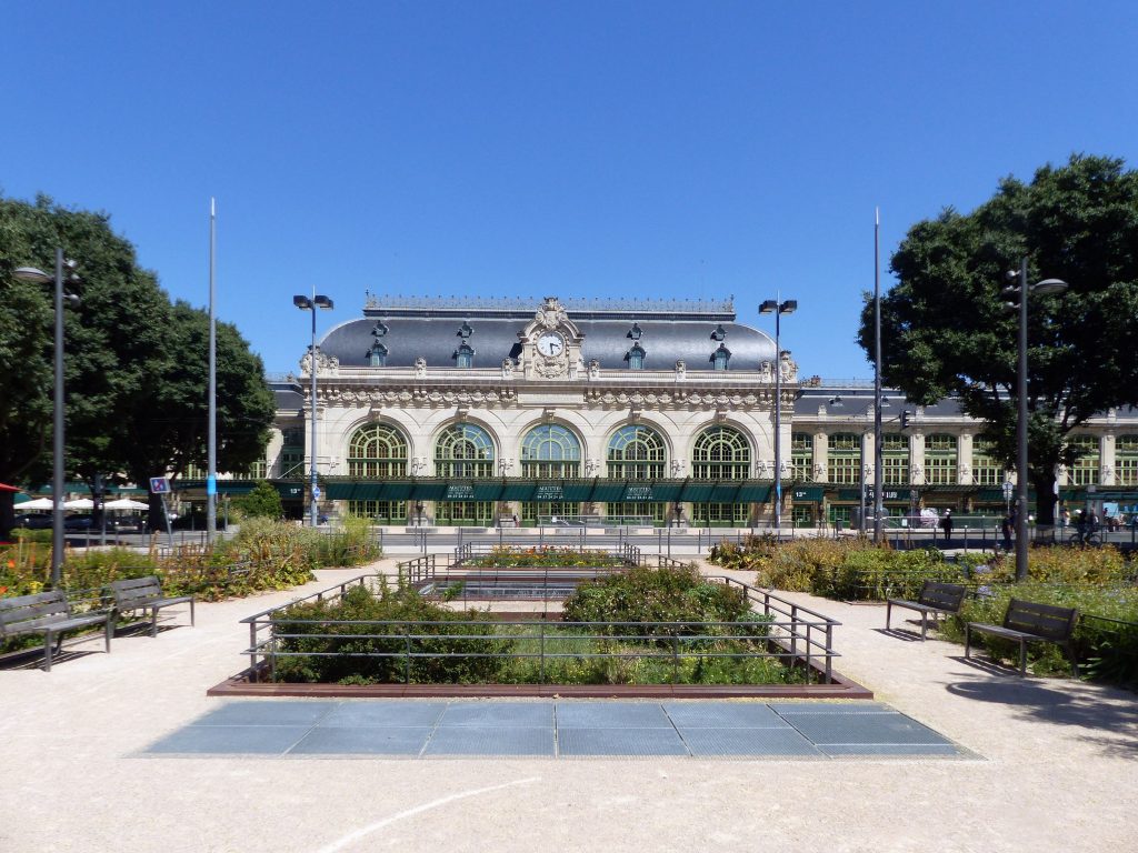 Discover the stunning Belle Époque architecture in Lyon's serene garden setting under a bright summer sky.